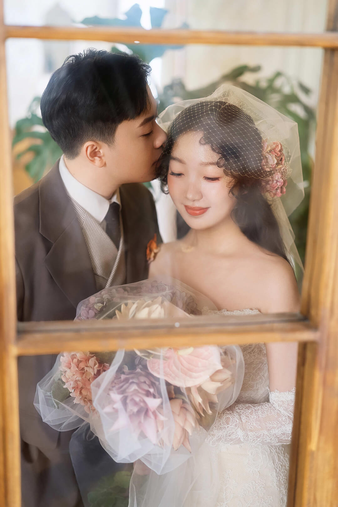 窗边亲吻的婚纱照